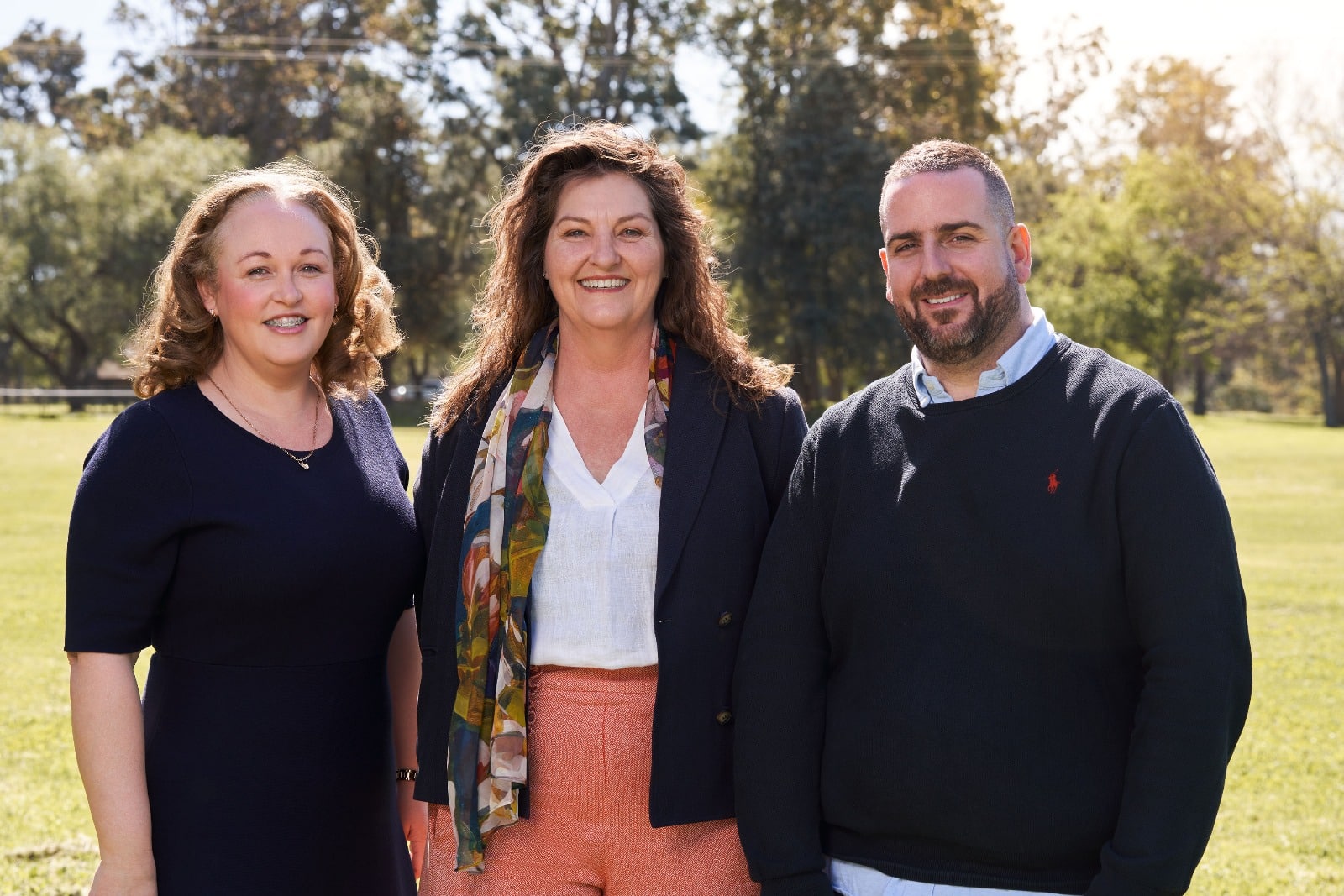 The Insightful Impact Directors standing in front of green trees outside